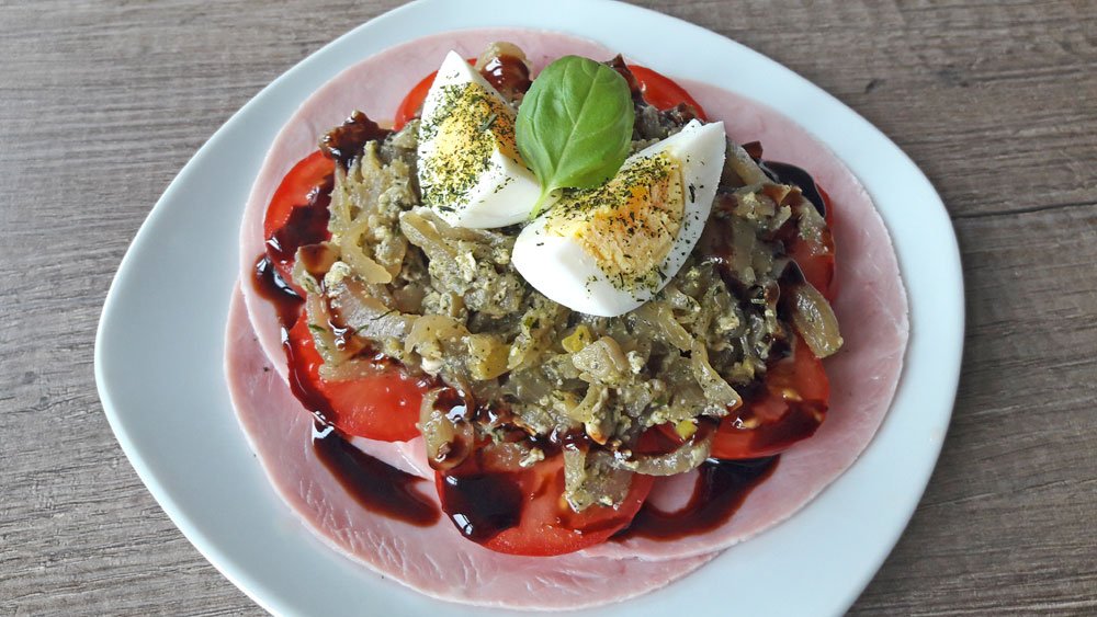 Schmorzwiebeln auf Kochschinken und Tomaten